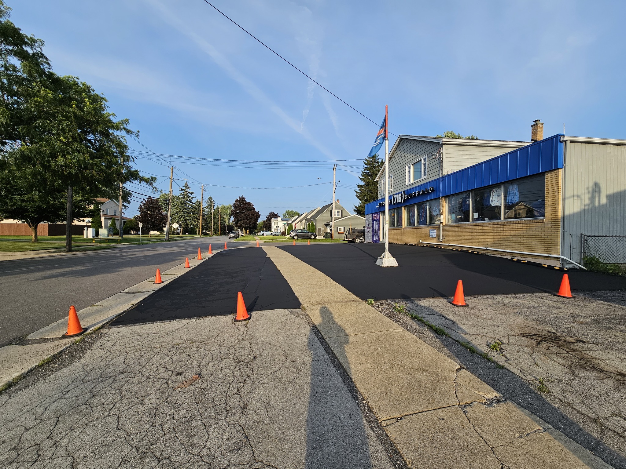 Storefront with fresh asphalt sealcoating and safety cones