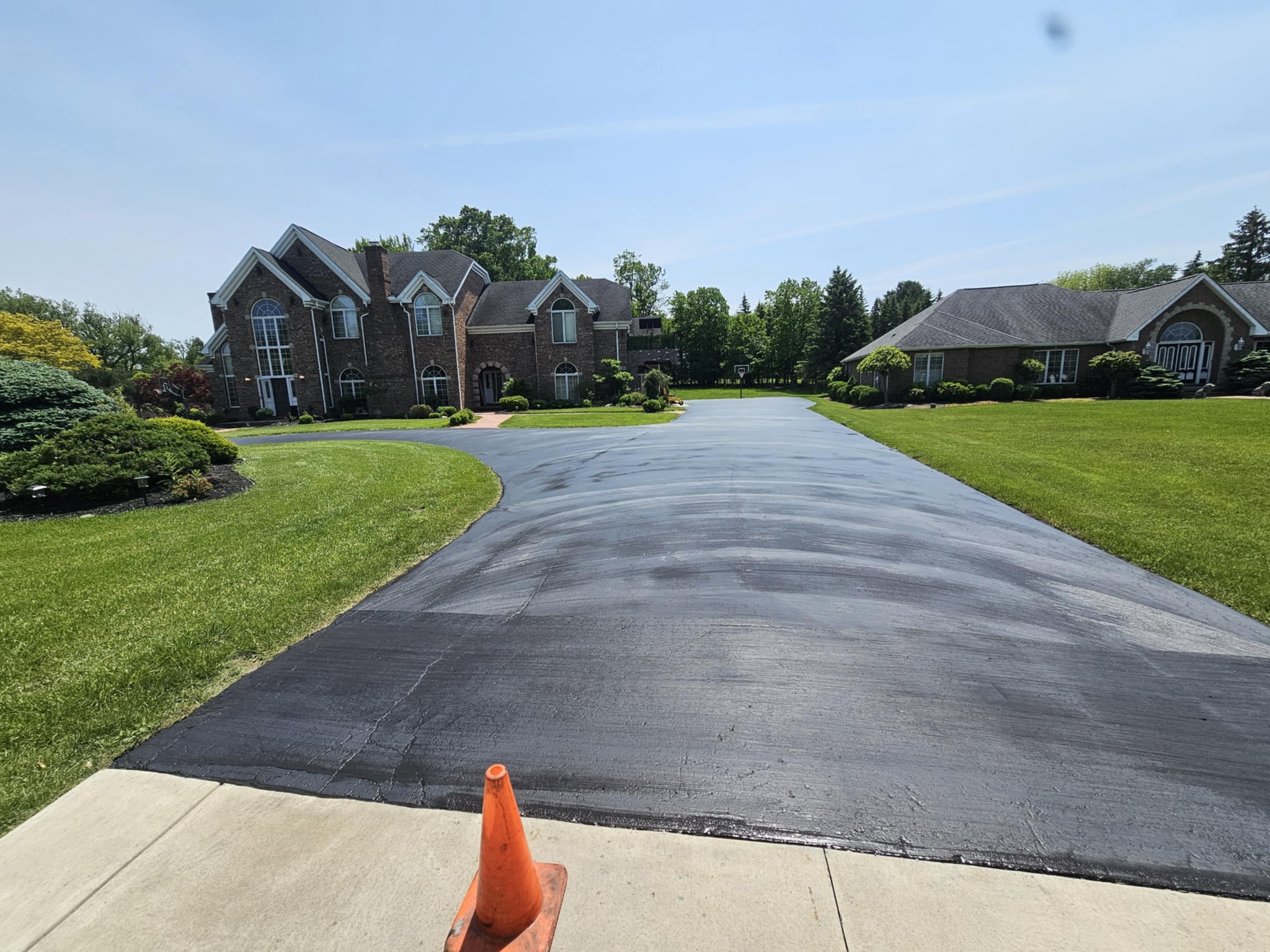 Brick estate with a long freshly sealed driveway