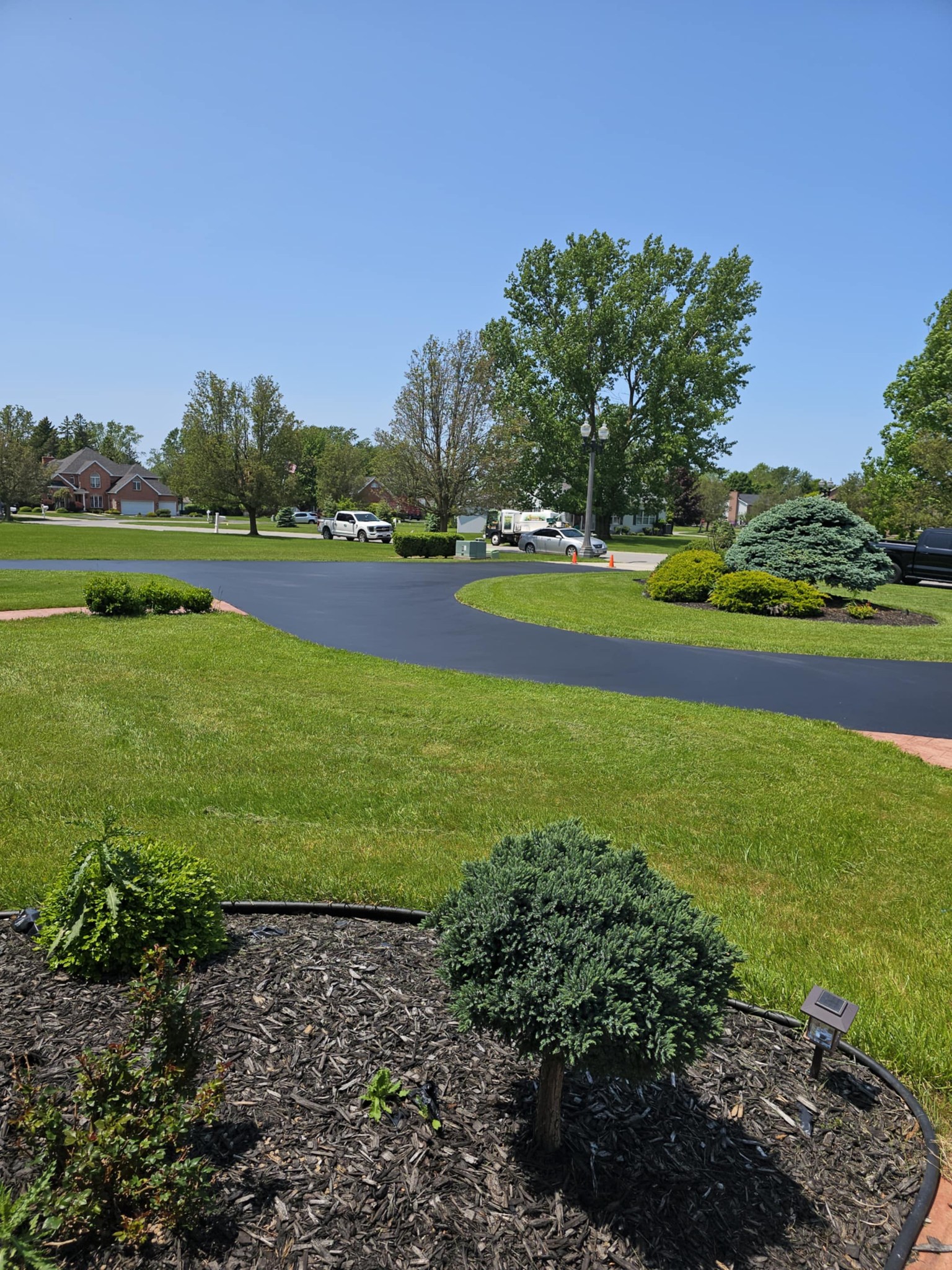 Curved luxury estate driveway with manicured landscaping