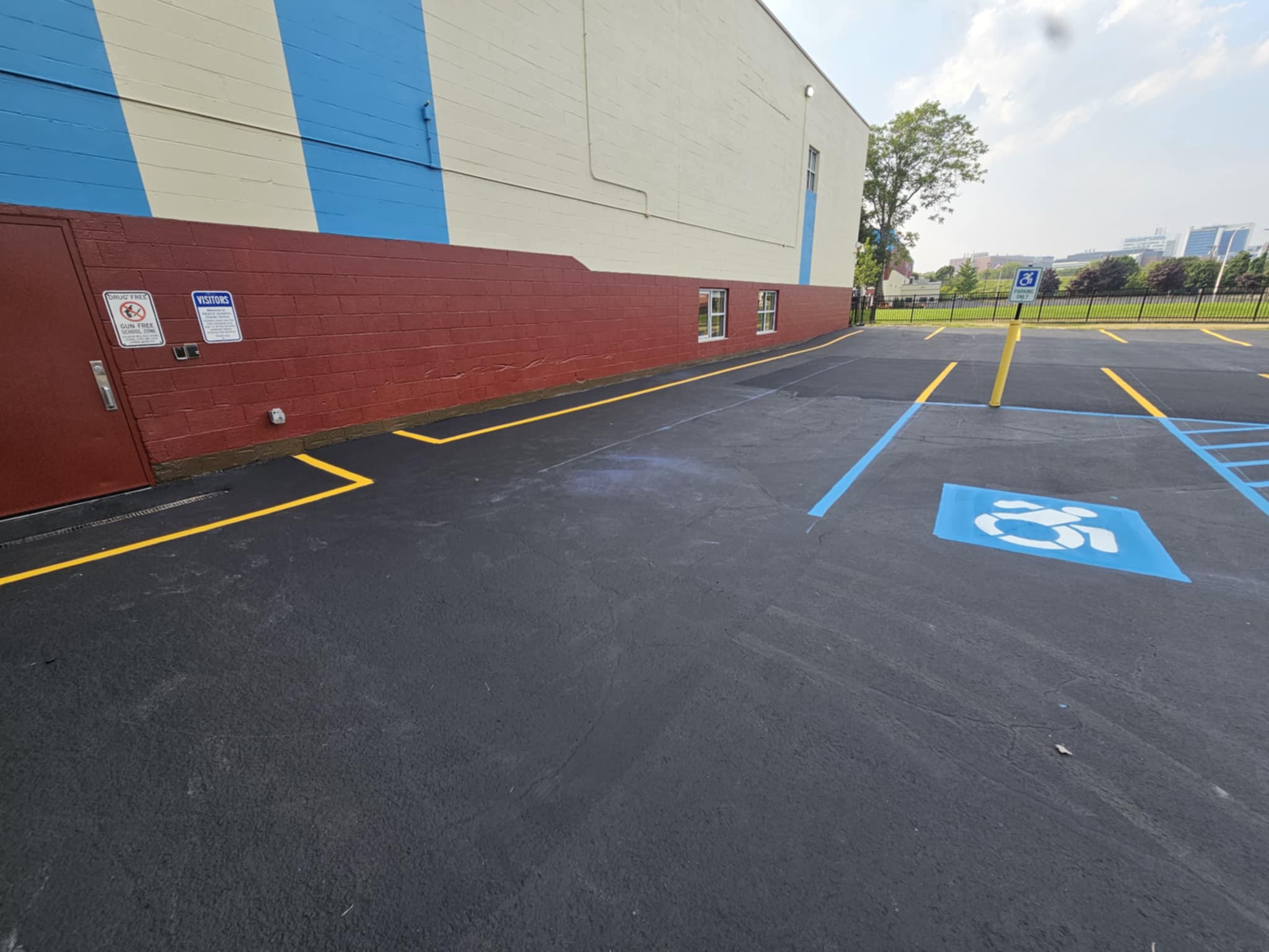 School parking lot with blue and yellow ADA accessible striping